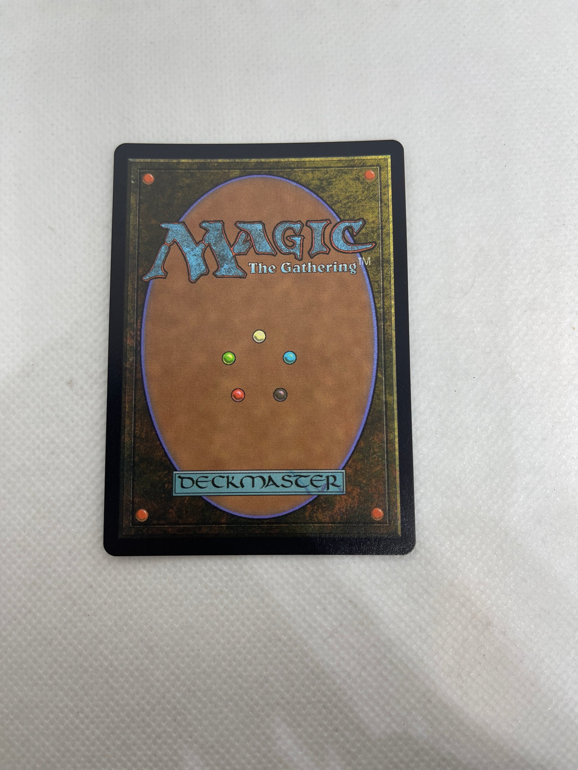 Card from 'Magic: The Gathering' with colorful dots on a gray background