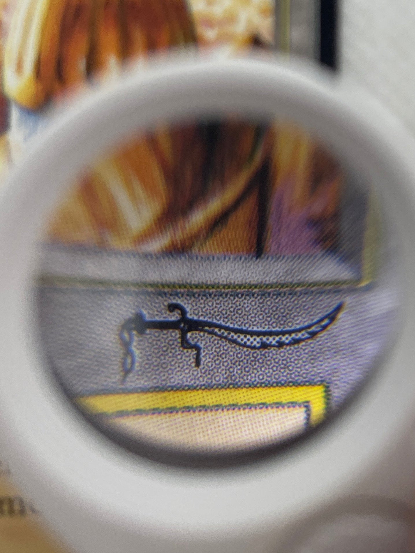 Close-up of a card with a magnifying glass held over it, on a white background