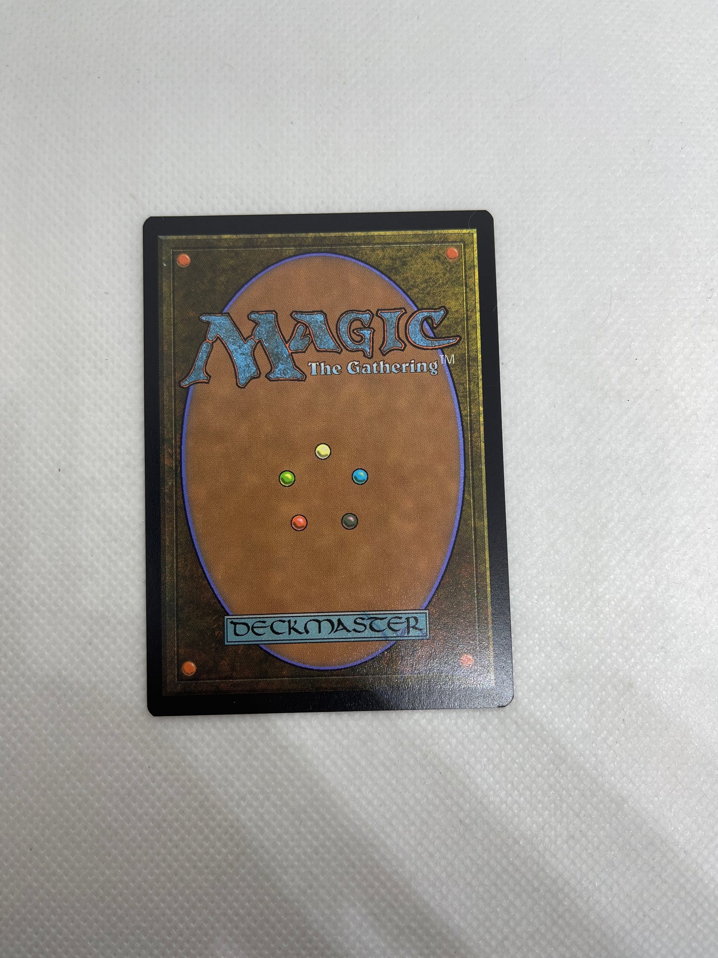Card from 'Magic: The Gathering' with colorful dots on a textured gray background