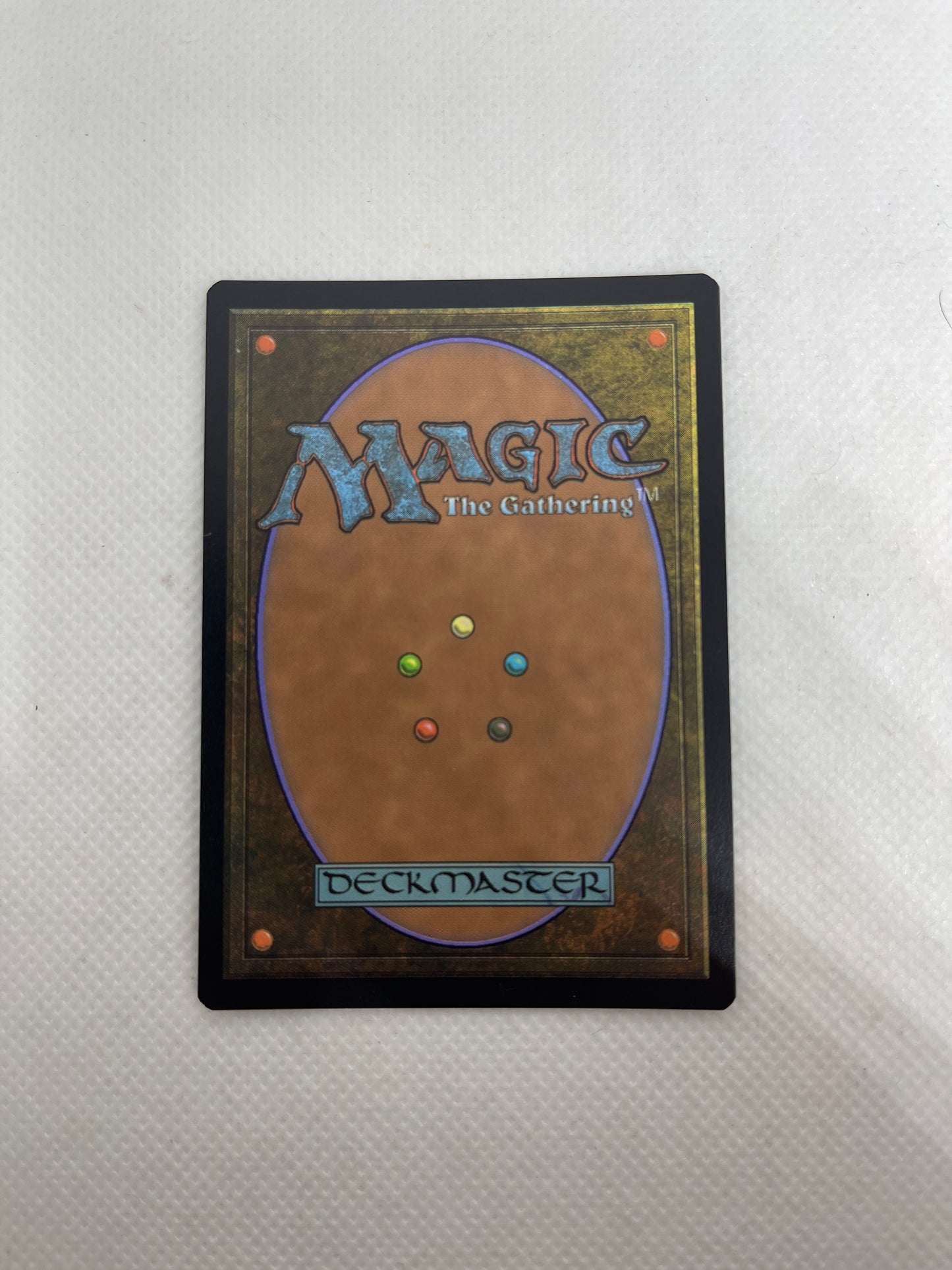 Magic: The Gathering deckmaster card on a textured surface