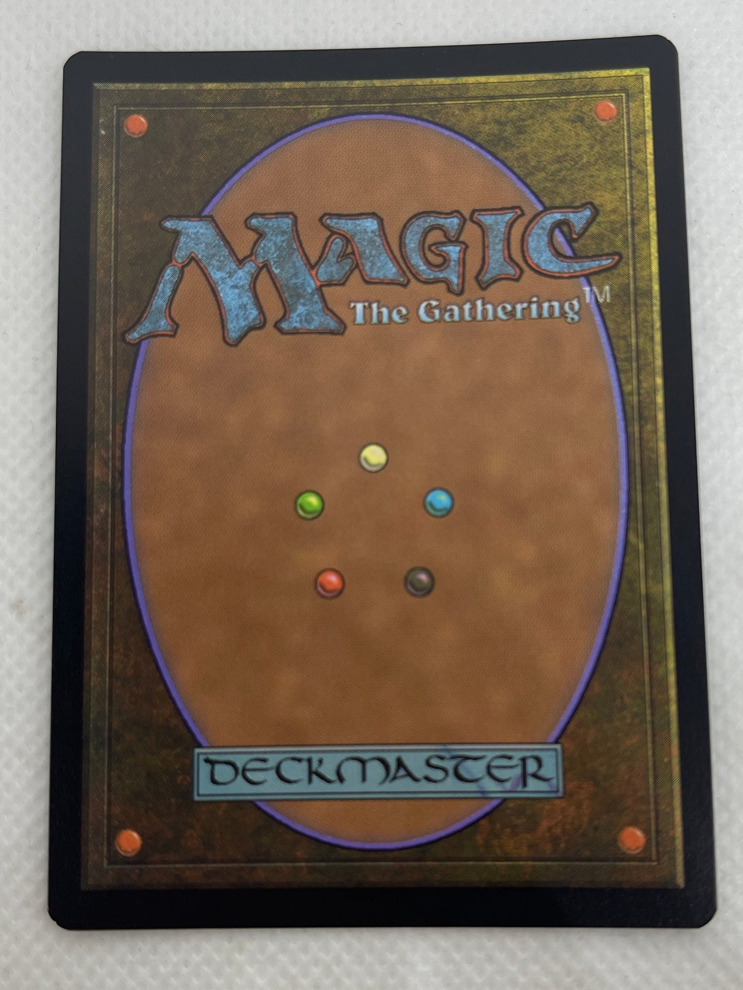 Magic: The Gathering card with small colored dots on a textured white surface