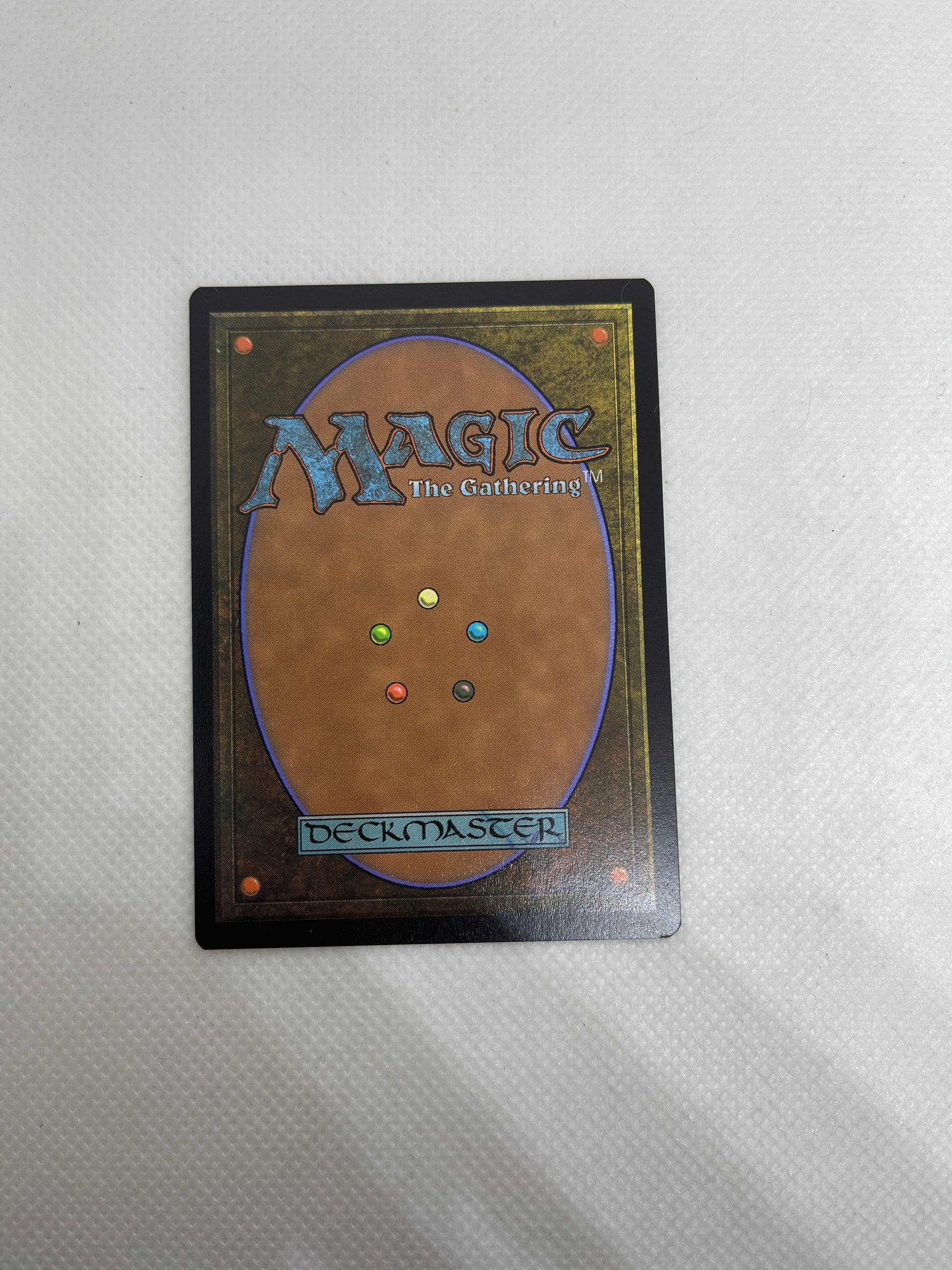 Card from 'Magic: The Gathering' with colorful dots on a textured gray background