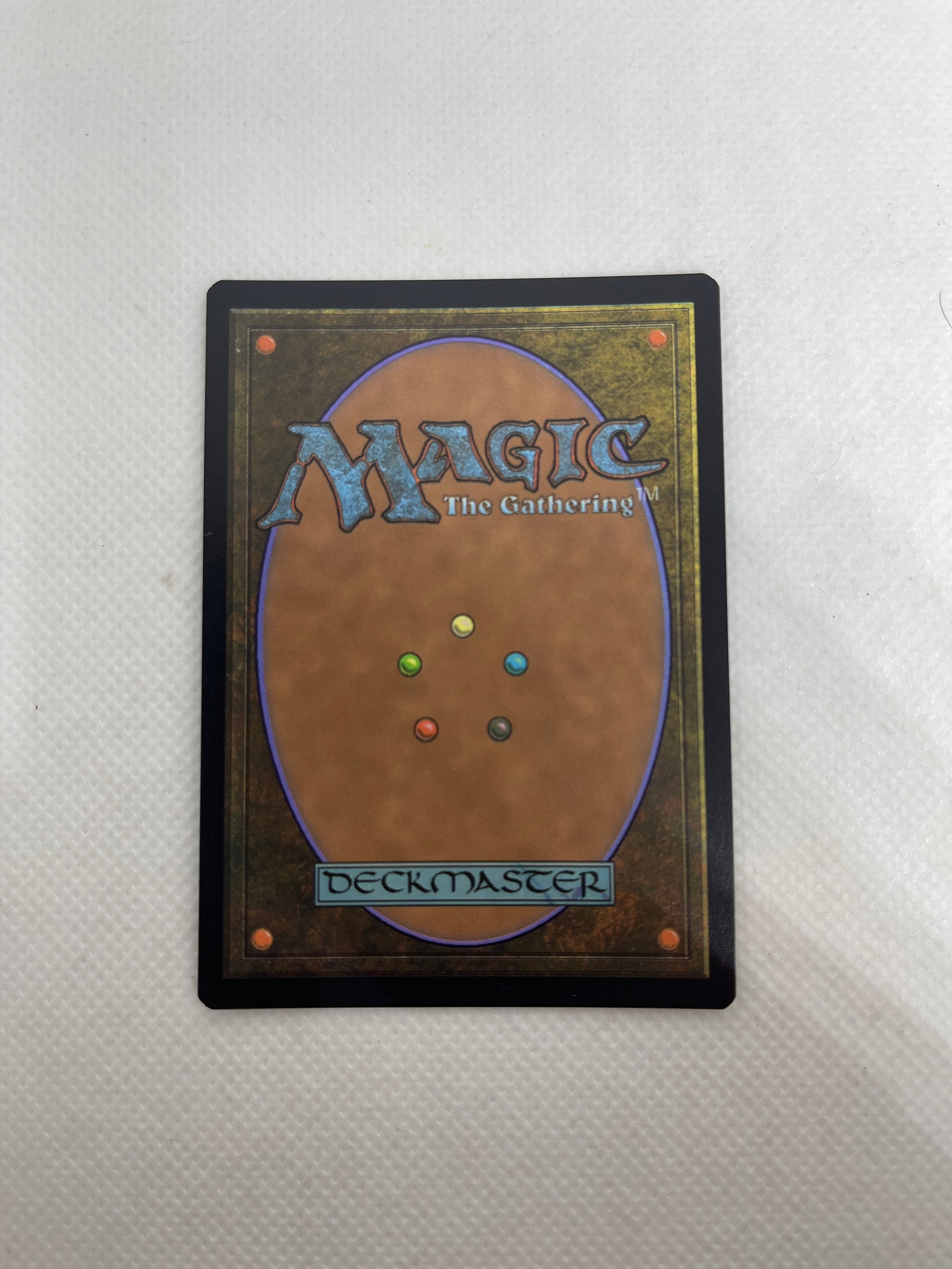 Magic: The Gathering deckmaster card on a textured surface